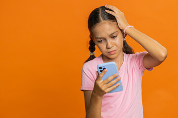 Upset sad preteen child girl kid use smartphone typing browsing, play game, loses, surprised by...