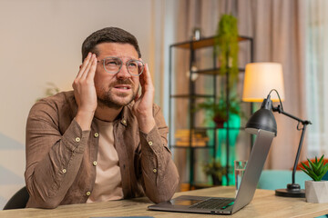 Tired ill Caucasian businessman suffering from headache problem tension and migraine stress at home...