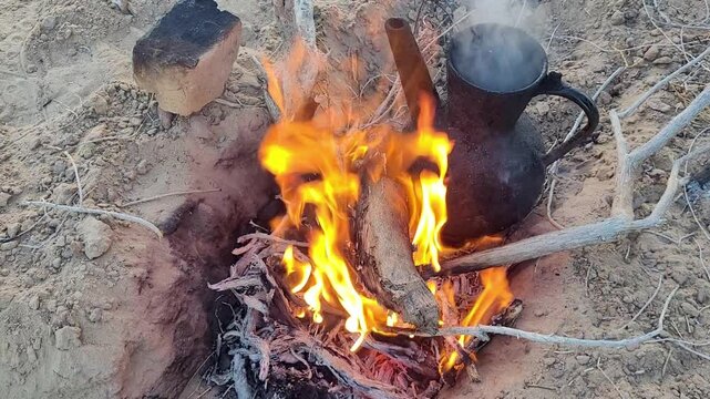 bonfire in the desert, a charred black kettle for boiling water. Karakum, Turkmenistan