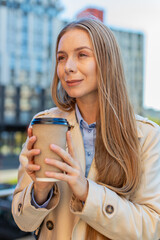 Happy mature businesswoman enjoying morning coffee hot drink and smiling outdoors. Relaxing, taking...