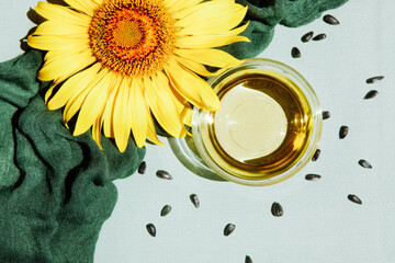 Sunflower flower with oil and seeds on the light green background, food ingredients 