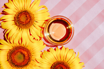 Sunflower oil with flowers from the top view on the light pink background with copy space