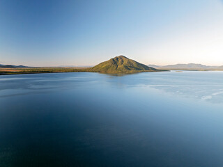 Obraz premium Aerial image of a rounded mountain rising from the bay in Queensland.