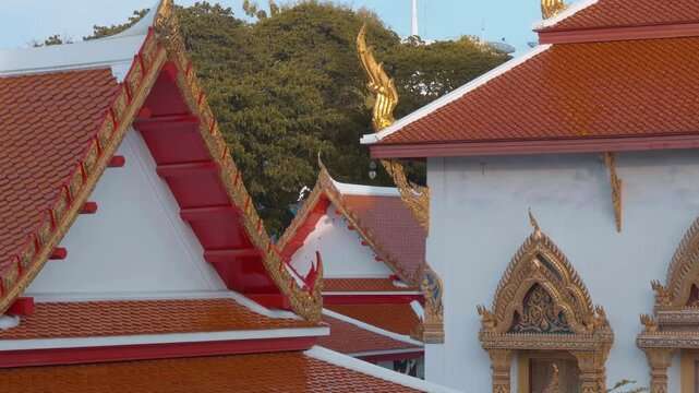 Traditional Thai Buddhist temple with beautiful red tiled roof with magnificent chofas in Thai architectural style. Shot in motion