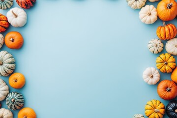 Colorful mini pumpkins frame a light-blue background