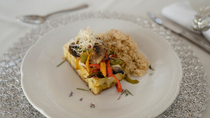 Social event gastronomy. Vegetarian menu. Closeup view of a mushrooms risotto with vegetables and a Spanish potato omelette	
