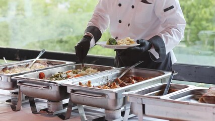 Catering service prepares a buffet with various dishes at an outdoor event