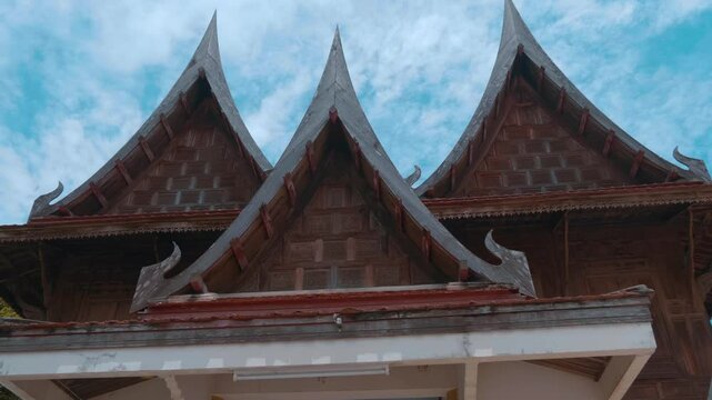 Skillfully crafted wooden gables with serpent shaped chofahs in traditional Ayutthaya style houses on a territory of Wat Na Phra Meru Buddhist temple in Ayutthaya province of Thailand. Shot in motion