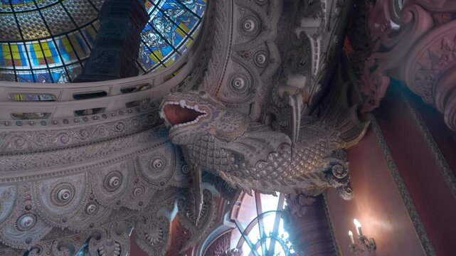 The interior of the  temple in Erawan Museum in Bangkok amazes visitors with its richness of detail. The walls are covered with ornate carvings, statues of dragons and other mythical creatures
