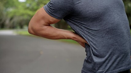 Man touch lower back. Running outdoor. Painful trauma. Radiculitis and muscle tension. Man runner has back pain closeup. Backache during running. Sport injury. Spinal compression and severe pain