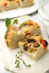 Pieces of delicious focaccia on white table, closeup