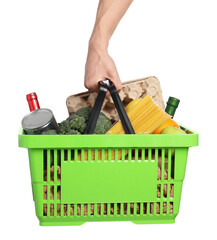 Man holding shopping basket with different products on white background, closeup