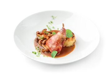 Baked rabbit leg with vegetable puree and mushrooms in plate isolated on white background. Meat dishes, top view, close up