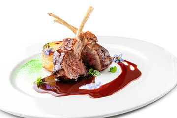 Roasted lamb chops or beef ribs meat with vegetable puree and sauce in plate isolated on white background. Meat dishes, top view, close up