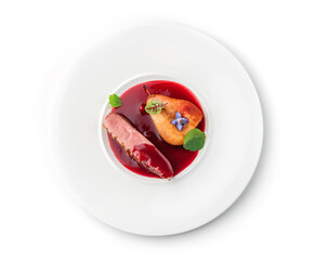 Grilled fillet beef steak or grilled beef medallion with baked pear and sauce in plate isolated on white background. Meat dishes, top view, close up