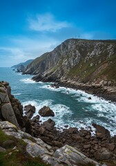 Obraz premium Coastal Rocky Cliff View With Turquoise Ocean Water Under Cloudy Sky Photo