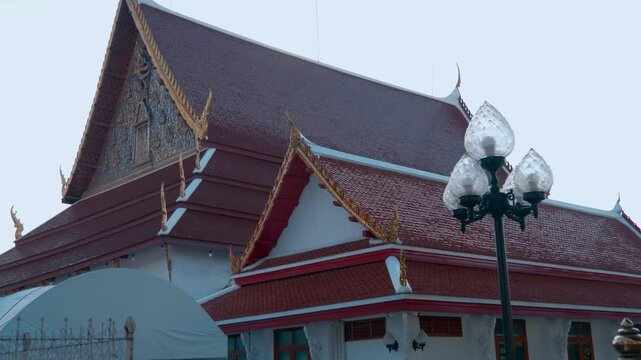 Famous white Buddhist temple near Khaosan road in Bangkok Thailand with traditional red tile roof. Shot in motion