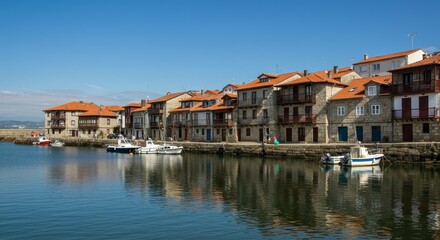 Photo of Coastal Town with Buildings at Waterfront Under Blue Sky with Reflection