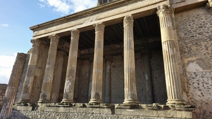 Obraz premium Pompeii, Italy - 8 January 2025. Close-up of the Basilica's main colonnade in Pompeii, Italy, showing tall fluted columns with Corinthian capitals and a partially intact entablature.