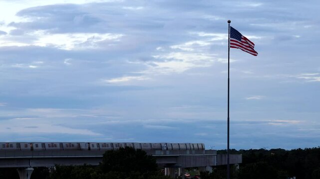 Washington DC USA A Washington DC Metro train passes under a large American flag at Dulles Airport. 