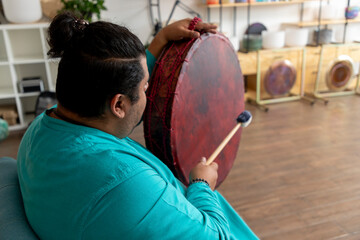 Fototapeta premium Musician playing large drum during sound healing session