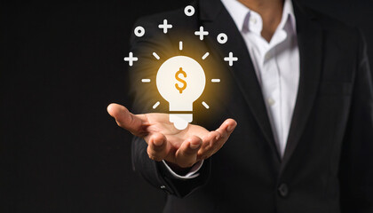 A businessman presents a glowing lightbulb with a dollar sign, symbolizing innovative financial ideas and success.