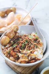 a bowl of chicken porridge with quail eggs satay, warm food
