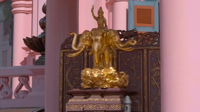 A golden statue of God Indra riding his mount Three-headed Elephant Erawan in front of the Erawan Museum in Bangkok, Thailand. Shot in motion