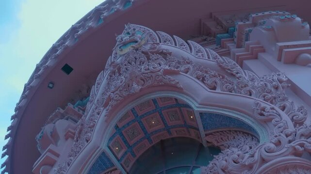 A pink pedestal decorated in traditional Thai style, on which stands the Three-Headed Erawan Elephant. Shot in motion