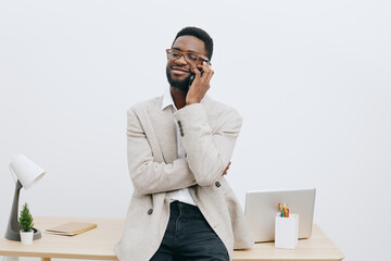 Smiling man wearing glasses and casual neutral blazer pose indoors at workplace with white...
