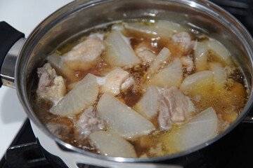 大根と鶏肉の煮物を作る様子