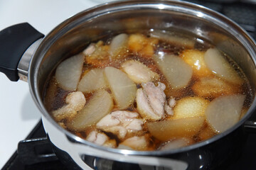 	大根と鶏肉の煮物を作る様子