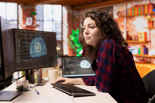 System administrator working in AI tech agency providing custom software development services. IT staff member using artificial intelligence technology to streamline coding process in startup office