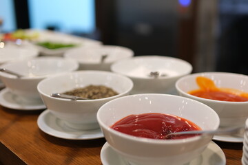 Bowls with different sauces and ingredients on gray background, flat lay. Space for text. High quality photo