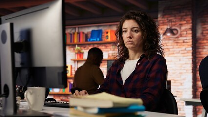 Woman using PC in startup office to design and implementing algorithms enabling machine learning....