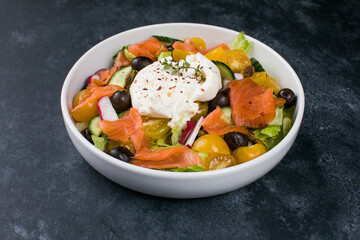 Easter brunch salad. Smoked salmon, buratta cheese, tomato, olive oil, lemon dressing salad on wooden background, top view. Flat lay