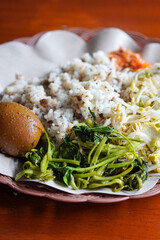 Tutug oncom rice with Sundanese vegetables, captured on May 23, 2025. Savory rice mixed with fermented soybean cake, served with fresh local greens from West Java
