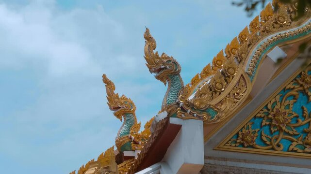 Amazing Ayutthaya-style dragon-like gilded chofahs and elements of the roof of Wat Na Phra Meru Buddhist temple in Ayutthaya province, Thailand. Shot in motion