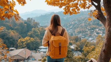 Woman with backpack enjoying autumnal mountain view