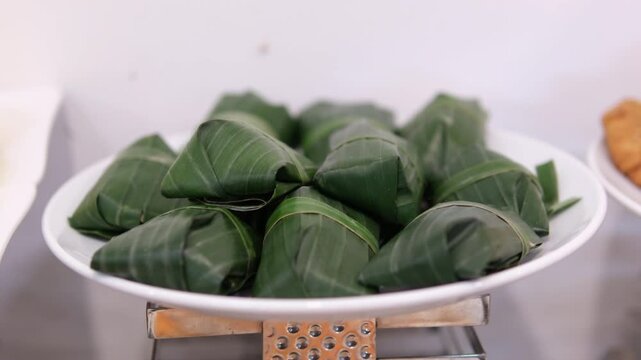 Fresh crabs neatly bundled in banana leaves, displayed for sale at a local market, highlighting traditional seafood preparation.