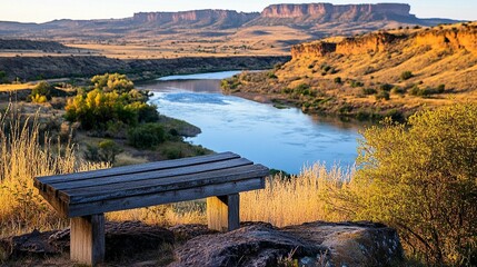 Wooden bench overlooks a serene river valley, with colorful hills in the background