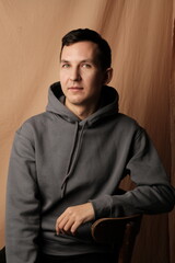 Obraz premium A Casual Portrait Depicting a Young Male Dressed in a Stylish Hoodie in a Studio Environment