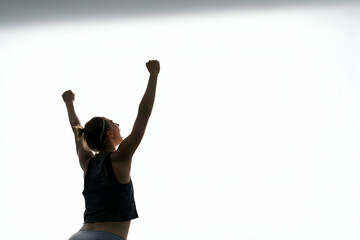 Obraz premium Woman Raising Arms in Celebration or Success on Bright Background, Fitness and Running Concept, free space for text
