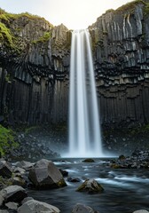Obraz premium Photo of Waterfall Flowing Through Basalt Columns Vertical Landscape Scene