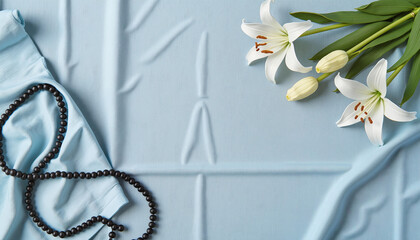 White lilies and rosary on blue background for Easter