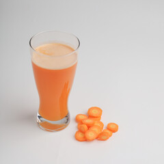 Carrot juice in a glass on white background