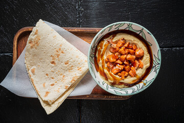 Creamy hummus with tender chicken and warm flatbread invites a taste adventure