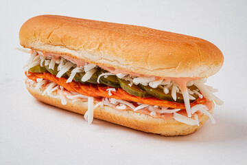 A colorful and appetizing sandwich stacked with pickles, shredded vegetables, and a savory spread