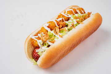 Savory hot dog with crunchy toppings, fresh lettuce, and a creative sauce drizzle