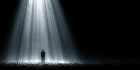Man standing under dramatic bright light rays shining down in a dark atmosphere with tiled floor